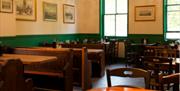 Goddard's at Greenwich, showing a green and white themed room with brown tables and chairs.