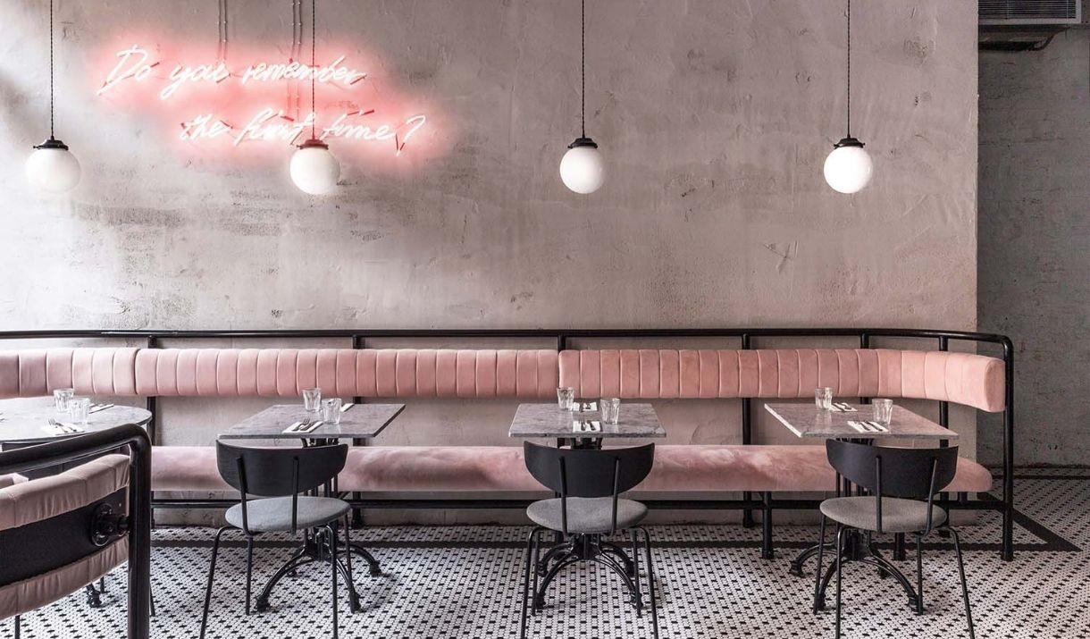 Interior image of Greenwich Grind branch with modern contemporary setting with natural light, pink seating and black and white tiled floor.
