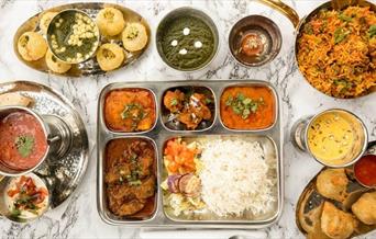 A table filled with Indian cuisine, at Hullabaloo Greenwich.