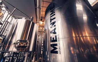 A glimpse of the inside of the MEANTIME Brewery with silver barrels.