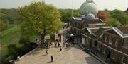 Royal Observatory and Meridian Courtyard in the day with Greenwich Park in the background