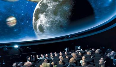 People sit in awe under the stars projected on the ceiling of the Peter Harrison Planetarium.