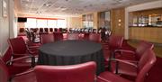 Inside the Royal Greenwich Suite, a large room with black tables and red chairs