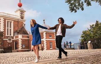A couple hold hands on the Meridian Line at the Royal Observatory