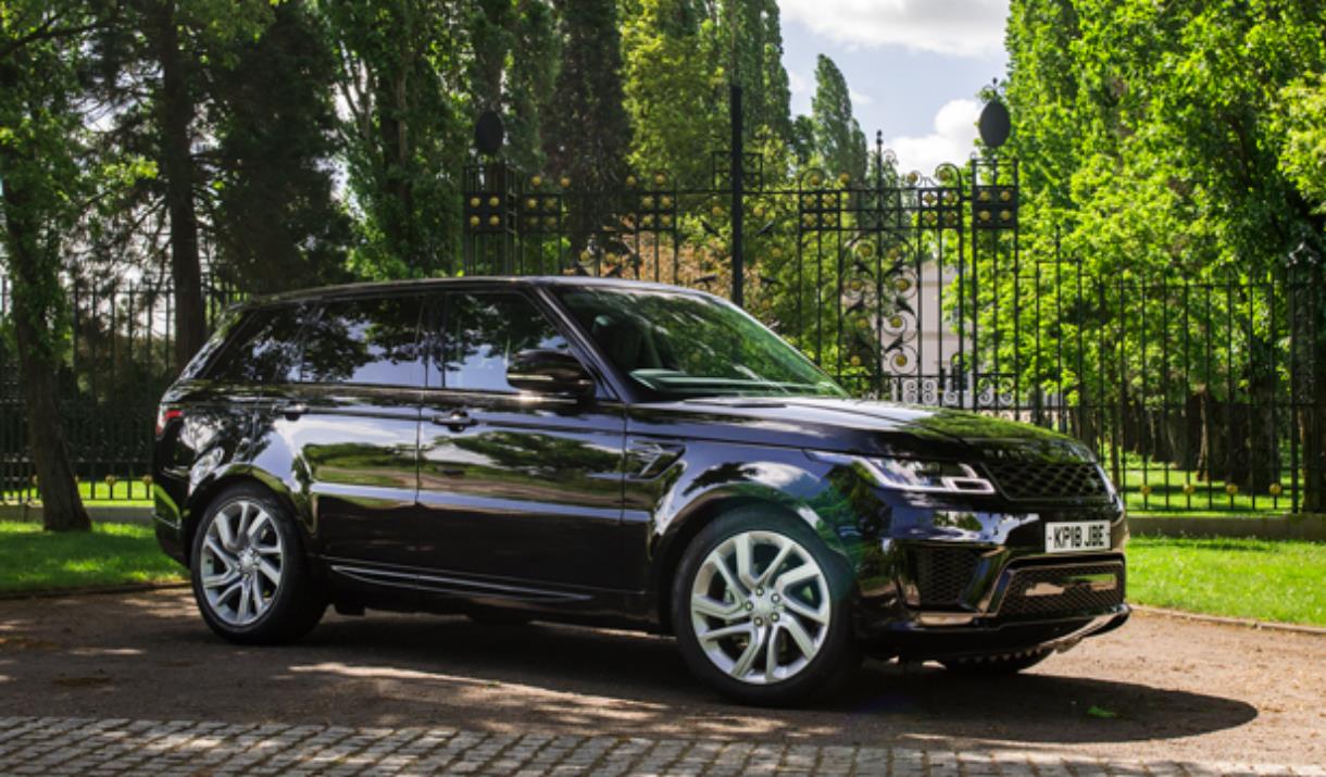 A black Range Rover outside an ornate black gate available to rent in Greenwich, London.