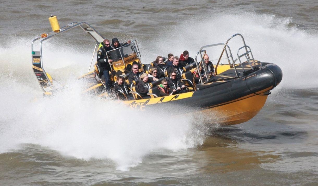 Black and yellow Thames RIB speedboat in action on river Thames.