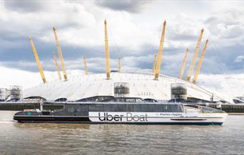 Uber Boat by Thames Clippers sailing on the River Thames overlooking The O2