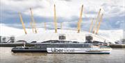 Uber Boat by Thames Clippers sailing on the River Thames overlooking The O2