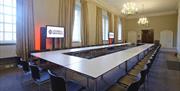 Tables and chairs setup in a boardroom layout in a meeting room in the University of Greenwich