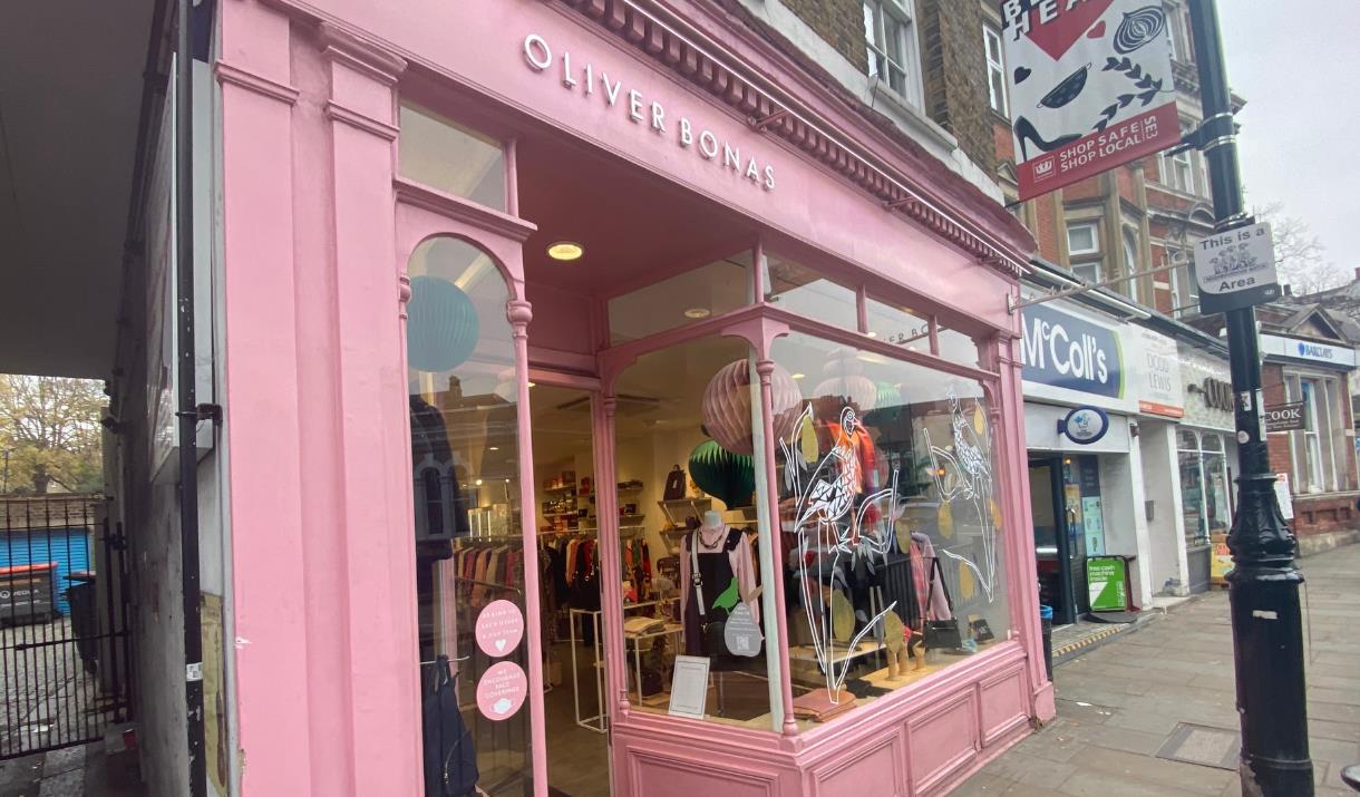 Outside Oliver Bonas in Greenwich. Showing a pink shopfront with lots to explore inside.