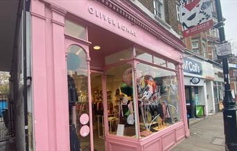 Outside Oliver Bonas in Greenwich. Showing a pink shopfront with lots to explore inside.