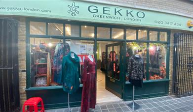 Outside GEKKO in Greenwich, showing a green shop front with a range of clothing on show.