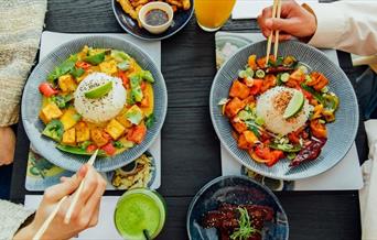 A selection of Wagamama vegan specialities including vegan ribs, chili squid, tofu firecracker and tofu raisukaree with delicious juices.